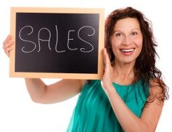 Vrouw met een bordje sale in haar hand